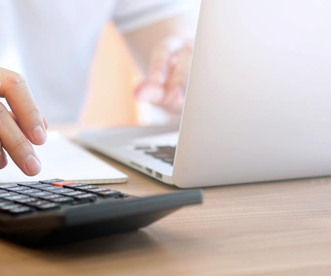 Person working with a laptop and a calculator